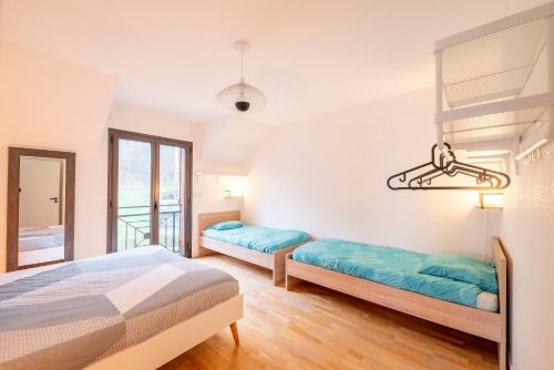 a bedroom with two beds and a window at Demoiselle Loue in Ornans
