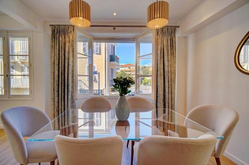 une salle à manger avec une table et des chaises en verre dans l'établissement MAGNIFIQUE 3 PIECES RENOVE CANNES CENTRE 'Banane' AVEC VERANDA ! A2B88, à Cannes