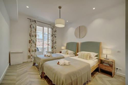 une chambre avec deux lits avec des serviettes dessus dans l'établissement MAGNIFIQUE 3 PIECES RENOVE CANNES CENTRE 'Banane' AVEC VERANDA ! A2B88, à Cannes