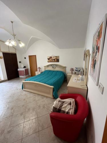 a bedroom with a bed and a red chair at Casa Rossella - Tricase zona Ospedale in Tricase
