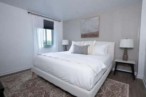 a white bedroom with a large bed and a window at Stunning Riverfront Getaway in Downtown Nashville in Nashville