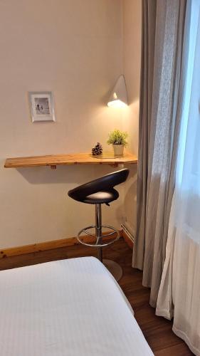 a room with a table and a stool next to a bed at B&B l'Edelweiss in Vallouise