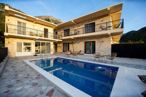 a house with a swimming pool in front of a building at Stone Villa with pool Montenegro Star in Kaluđerac