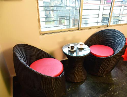 two chairs and a table in front of a window at City Central Hostel in Kolkata