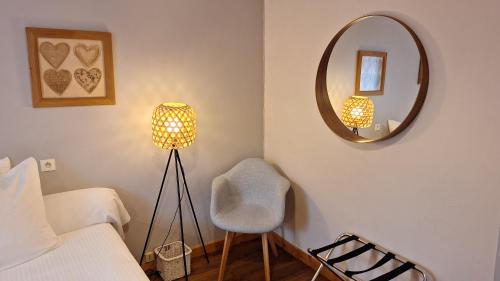 a bedroom with a bed and a mirror and a chair at B&B l'Edelweiss in Vallouise