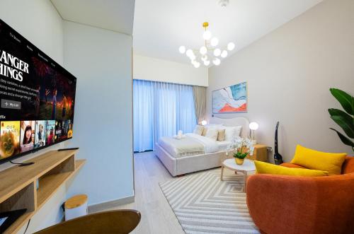 ein Wohnzimmer mit einem Bett und einem Fernseher in der Unterkunft Elegant Studio with Pool Access & Private Terrace in Dubai