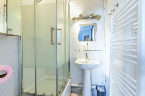 une salle de bain avec une douche en verre et un lavabo dans l'établissement Appartement confortable Montparnasse 14ème arrondissement, à Paris