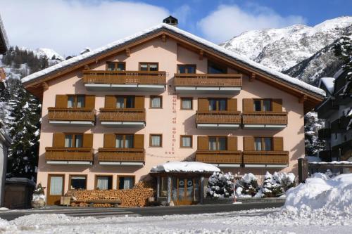 hotel w górach ze śniegiem na ziemi w obiekcie Albergo du Soleil w mieście Cogne
