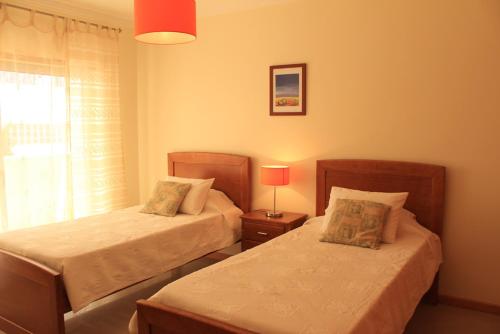 a bedroom with two beds and a window at Akisol Albufeira Aqua II in Albufeira