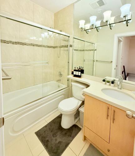a bathroom with a toilet and a sink and a shower at Modern & Cozy 2-Bed Suite in Vancouver in Vancouver