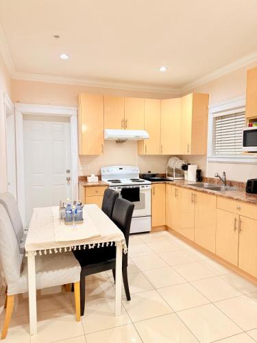 a kitchen with a table and a table and chairs at Modern & Cozy 2-Bed Suite in Vancouver in Vancouver