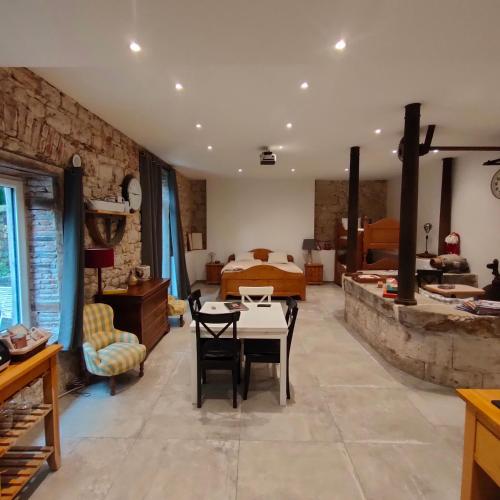 une chambre avec un lit, une table et des chaises dans l'établissement Gites du Longevent Appartement du Moulin Pérouges, à Meximieux