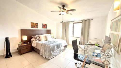 a bedroom with a bed with a ceiling fan and a desk at San Angel Villas in San Antonio