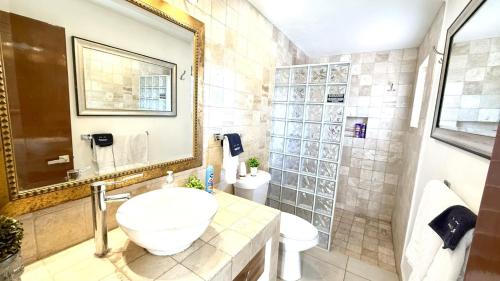 a bathroom with a sink and a toilet and a mirror at San Angel Villas in San Antonio