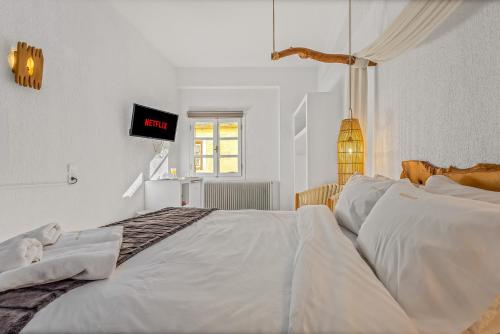 a white bedroom with a large bed with white sheets at Blue Mountain Guesthouse by Seablue in Arachova