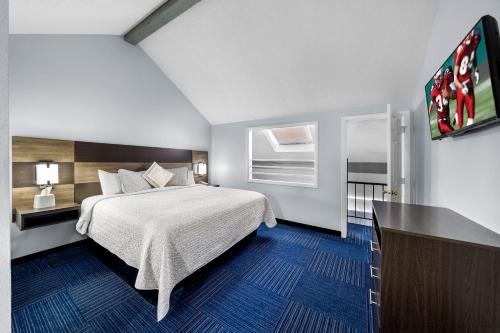 a hotel room with a bed and a flat screen tv at Admiralty Inn & Suites - a Red Collection Hotel in Falmouth