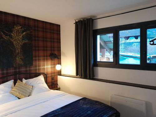 a bedroom with a bed and a window at Le Lodge Morgane Appartement 4 personnes in Barraux