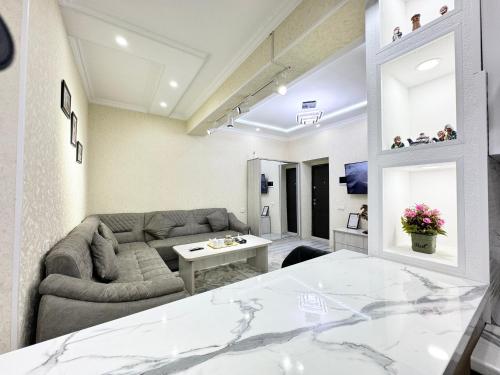 een woonkamer met een bank en een tafel bij Modern 2BR Luxury -10 Min Walk to Old Town in Bukhara