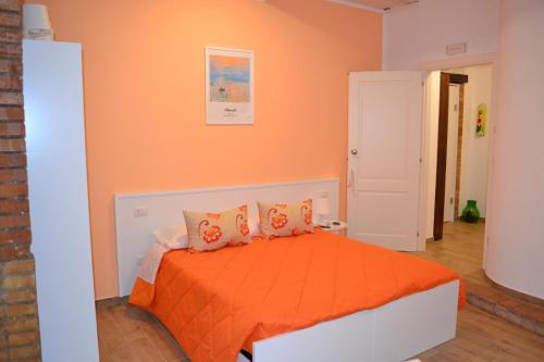 a bedroom with an orange bed with orange sheets and pillows at B&b la bottega in Trebisacce
