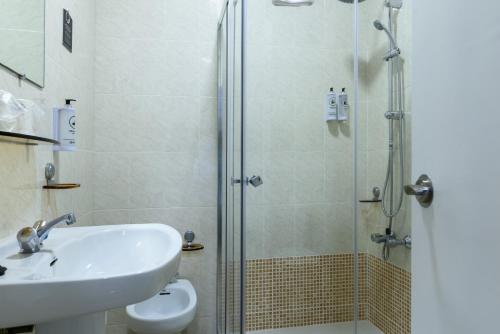 a bathroom with a shower and a sink and a toilet at Hotel Alda Narón in Narón