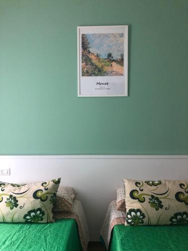 a picture hanging on a wall above two beds at B&b la bottega in Trebisacce