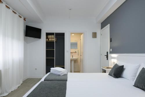 a bedroom with a large bed and a tv at Hotel Alda Narón in Narón