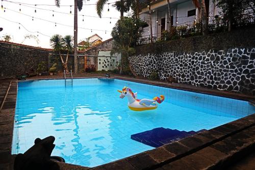 a swimming pool with a toy horse and a float at PLUM Hotel Palereman Batu in Batu