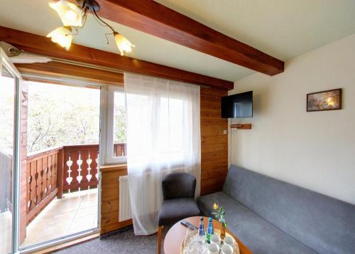a room with a chair and a table and a window at Dom Wypoczynkowy Topaz in Szklarska Poręba