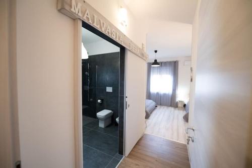 a hallway with a bathroom with a toilet and a mirror at Luz de Salento B&B in Lecce