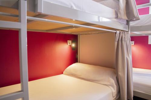 two bunk beds in a room with red walls at room00 Valencia Hostel in Valencia