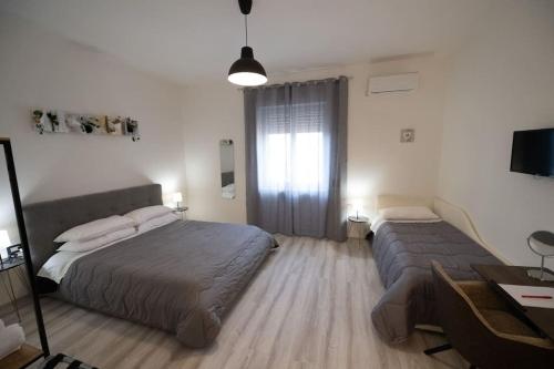 a bedroom with two beds and a desk and a window at Luz de Salento B&B in Lecce