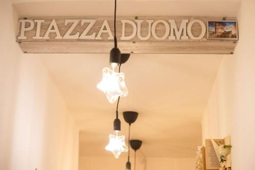 a chandelier hanging from a ceiling with a pharmacy sign at Luz de Salento B&B in Lecce