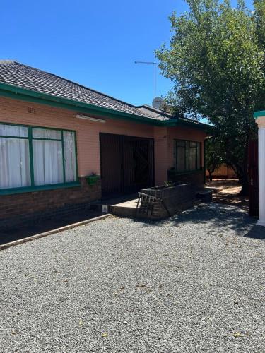 a house with a gravel driveway in front of it at Mos Elkin Home in Kimberley