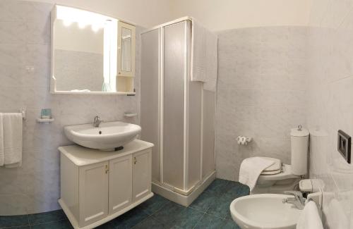 een witte badkamer met een wastafel en een toilet bij Apartment Tysandros in Giardini Naxos