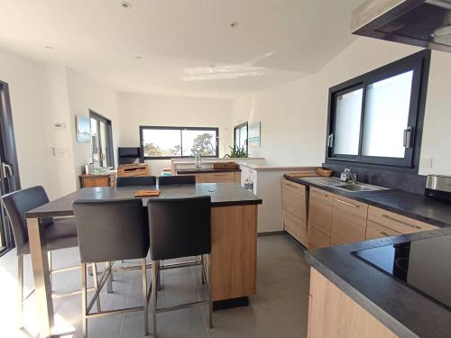 une cuisine avec une table et quelques chaises dans l'établissement Maison neuve Vue Mer 4 étoiles avec SAUNA à 150m de la plage à PLEUMEUR-BODOU - Ref 242, à Pleumeur-Bodou
