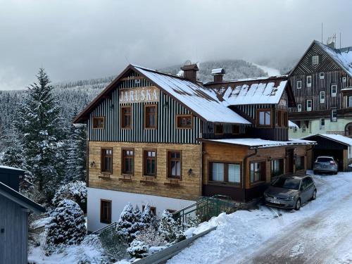 a wooden house with snow on the roof at Pension Jaruska in Špindlerův Mlýn