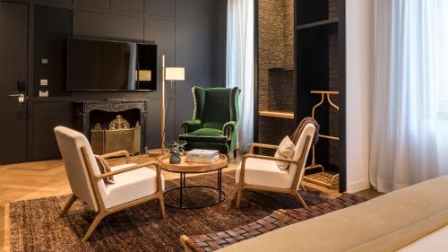 a living room with three chairs and a fireplace at Hotel Casa Sagnier in Barcelona