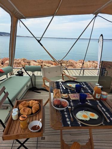 - une table avec petit-déjeuner sur un bateau dans l'établissement Hébergement insolite en demi-pension et excursion gastronomique en bateau, à Bouzigues