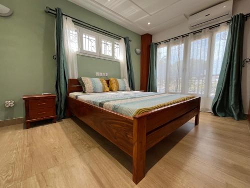 a bedroom with a wooden bed with a window at Appartement moderne de standing au cœur de Lomé in Lomé