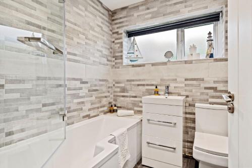 a bathroom with a tub and a sink and a shower at The Willows in Oxwich