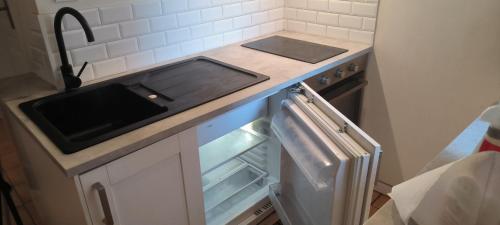 une cuisine avec un évier et une cuisinière dans l'établissement maison de village, à La Valette-du-Var