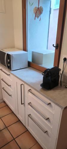 une cuisine avec un comptoir avec un micro-ondes dessus dans l'établissement maison de village, à La Valette-du-Var