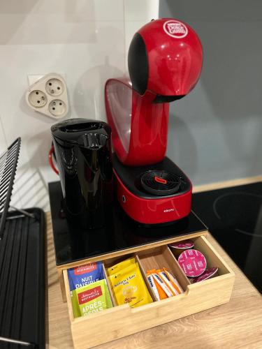 une cafetière rouge assise au-dessus d'un comptoir dans l'établissement Appartement climatisé Disney- Val D'europe, à Serris