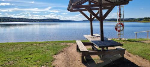 a bench sitting next to a body of water at Gårdshus 1 in Örby