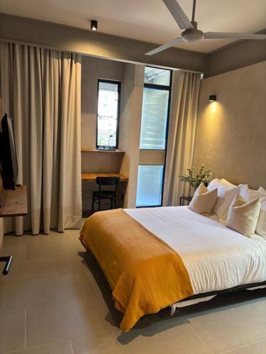 a bedroom with a large bed and a desk at Departamentos y Suites Índigo in Querétaro