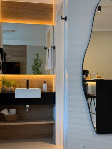 a bathroom with a sink and a mirror at Flat Vista Mar Praia Long Stay in Vitória
