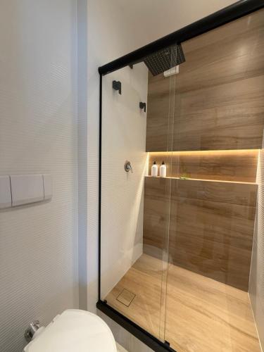a bathroom with a glass shower with a toilet at Flat Vista Mar Praia Long Stay in Vitória