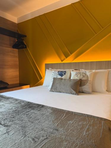 a bed with white pillows on it in a room at Flat Vista Mar Praia Long Stay in Vitória