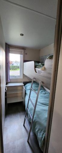 une chambre avec deux lits superposés et une fenêtre dans l'établissement jurfftyg, à Biville-sur-Mer