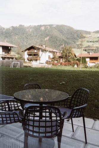a patio table and chairs with a view of a field at Lebe`schlitters - Das Ferienapartmenthaus im Zillertal in Schlitters